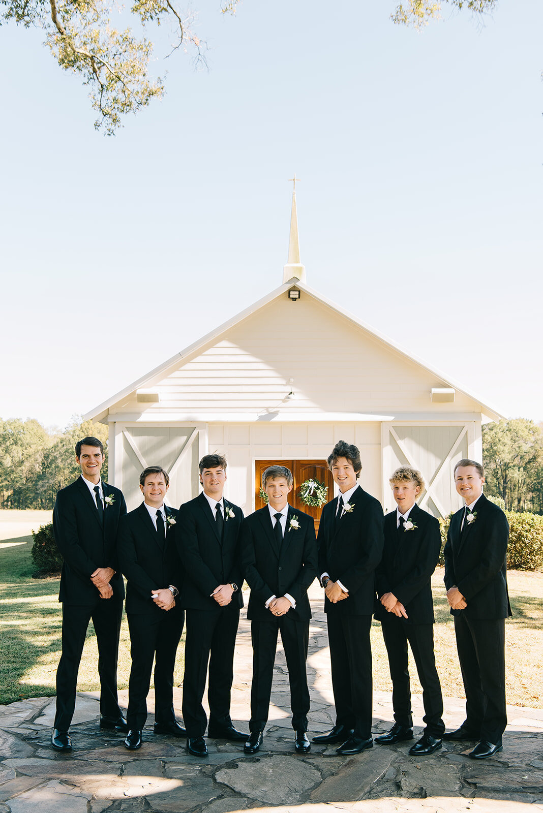 Groomsmen with white and green boutonnieres designed by Abby Grace Florals at Saluda SC wedding