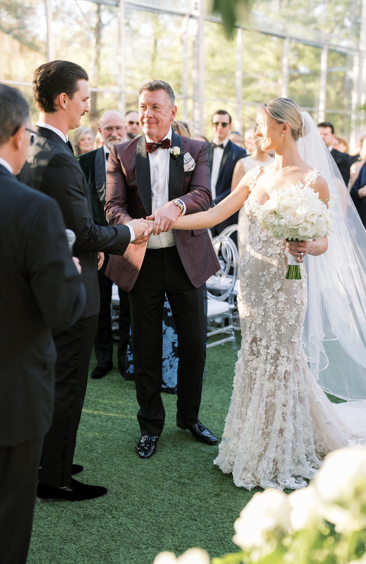 Bride walking down the aisle at Hotel Drover, in a tented ceremony with greenery hanging from the chandeliers