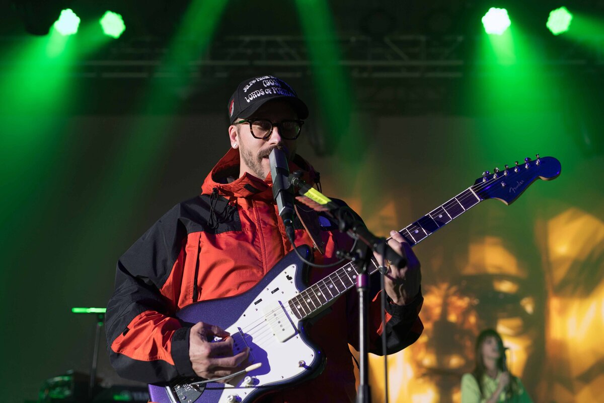 John Gourley sings with guitar at performance in Hawaii