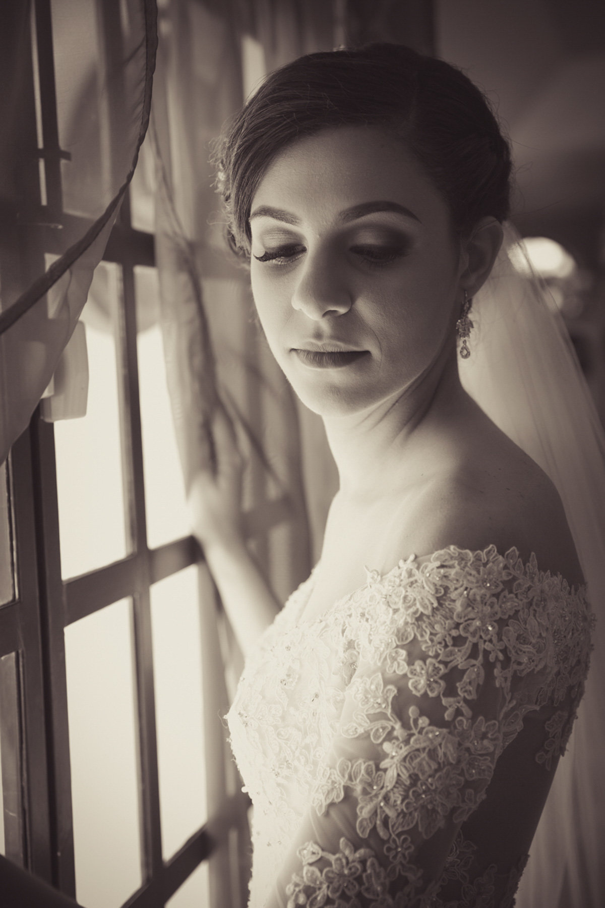 Glamour shot of bride against window in B+W. Photo by Ross Photography, Trinidad, W.I..