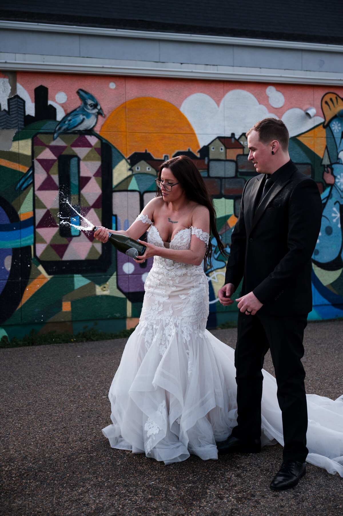 wedding couple pops a bottle of champagne