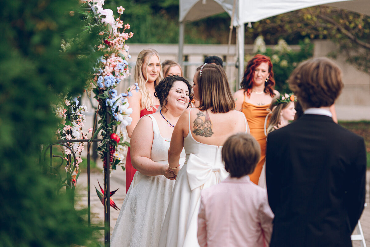 A queer couple has their wedding ceremony in the Cancer Survivors Garden at Maggie Daley Park
