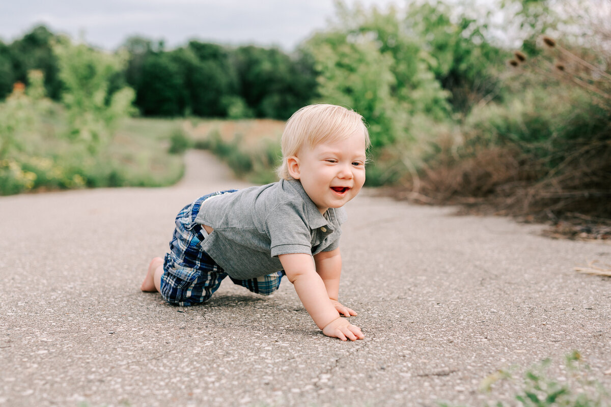 baby crawling and laughing on a path