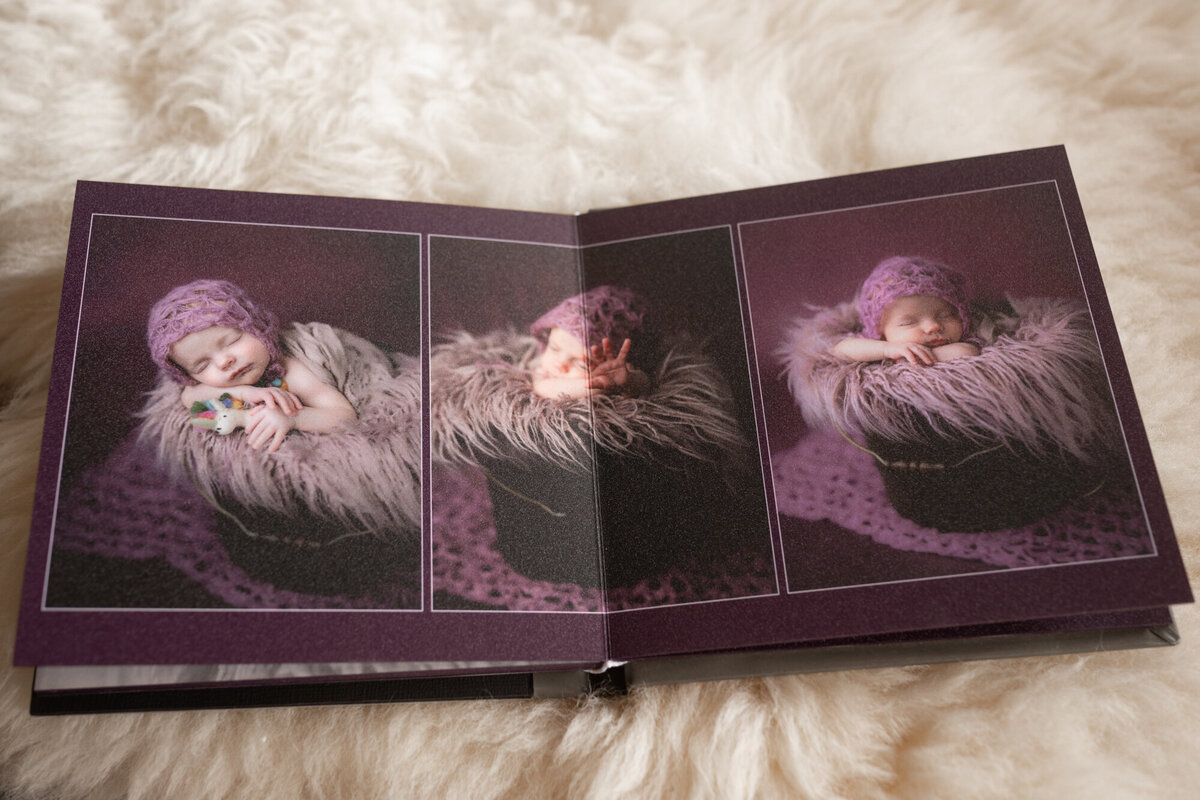 An open photo album to a centerfold sits on a white fur blanket