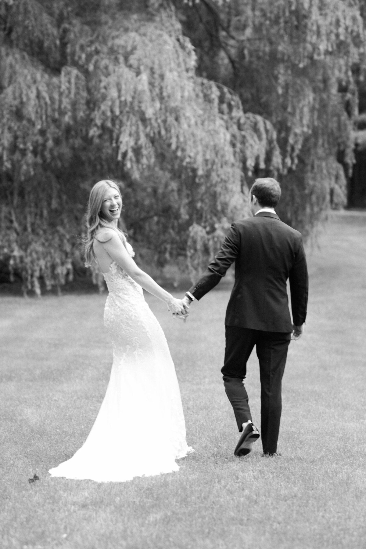 Newlyweds walk away and the bride looks back smiling 