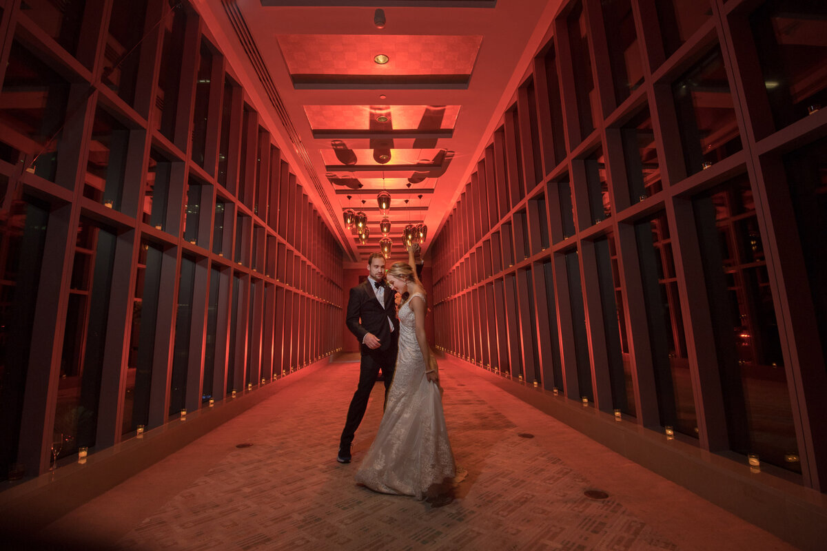 Bride and groom dancing in a modern, red-lit hallway at a Miami wedding venue, photographed by Rodrigo Varela Photography