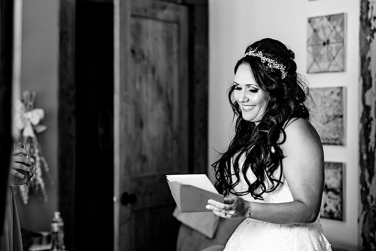 Black and White photo of bride reading a note from her husband