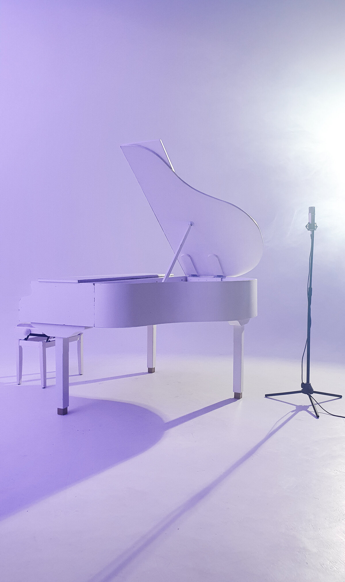 white baby grand piano in studio