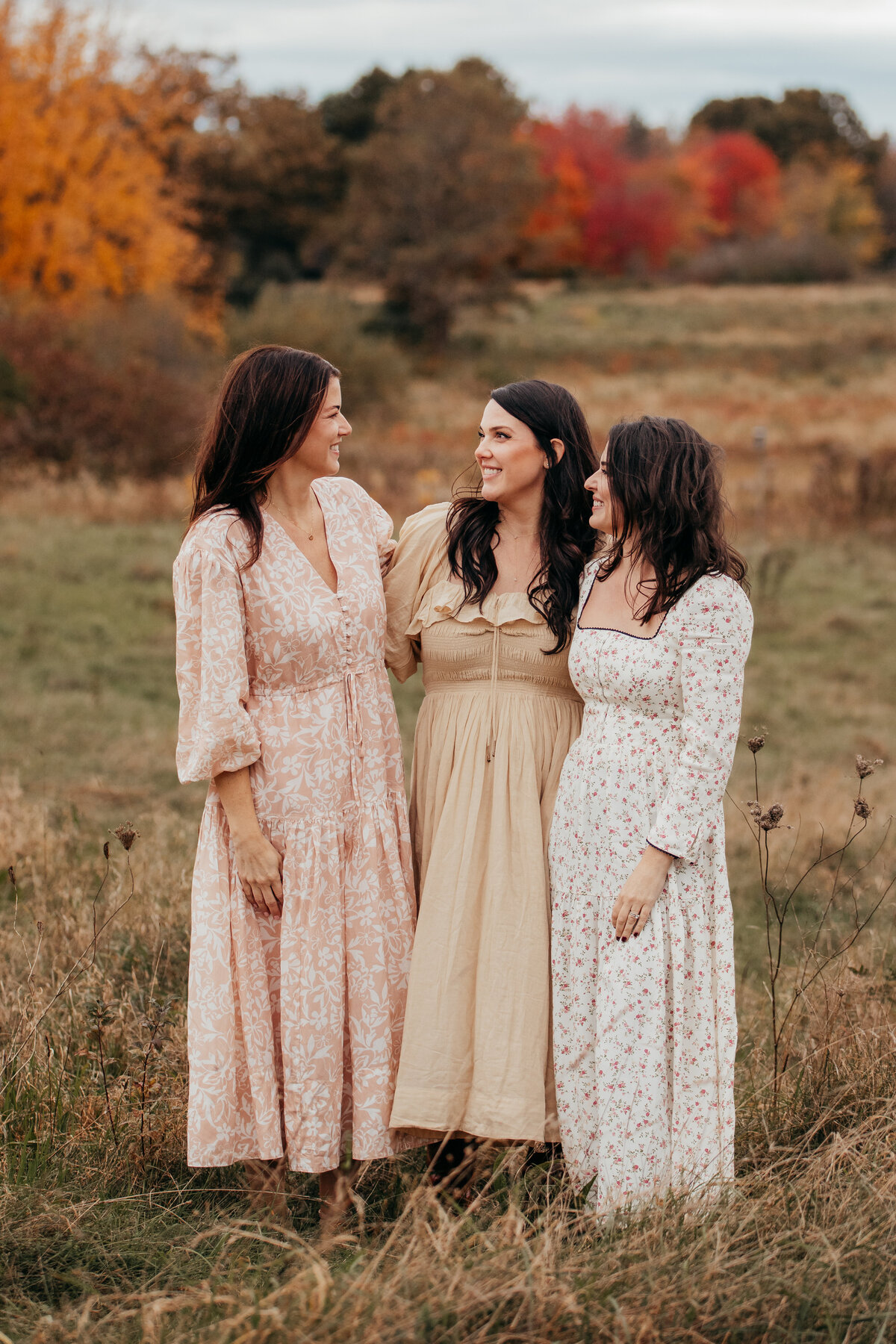 fall field family photo of sisters in dresses candid