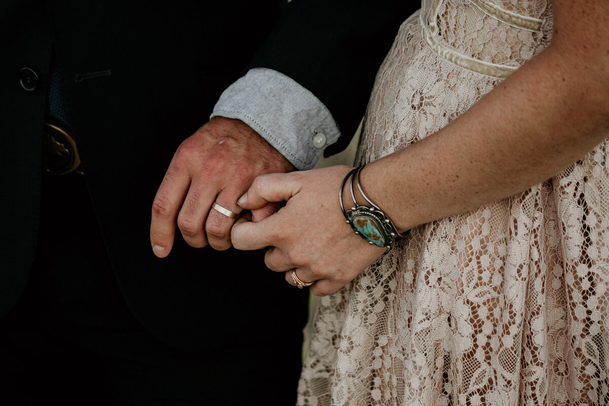 bride and groom hands with turquoise jewelry