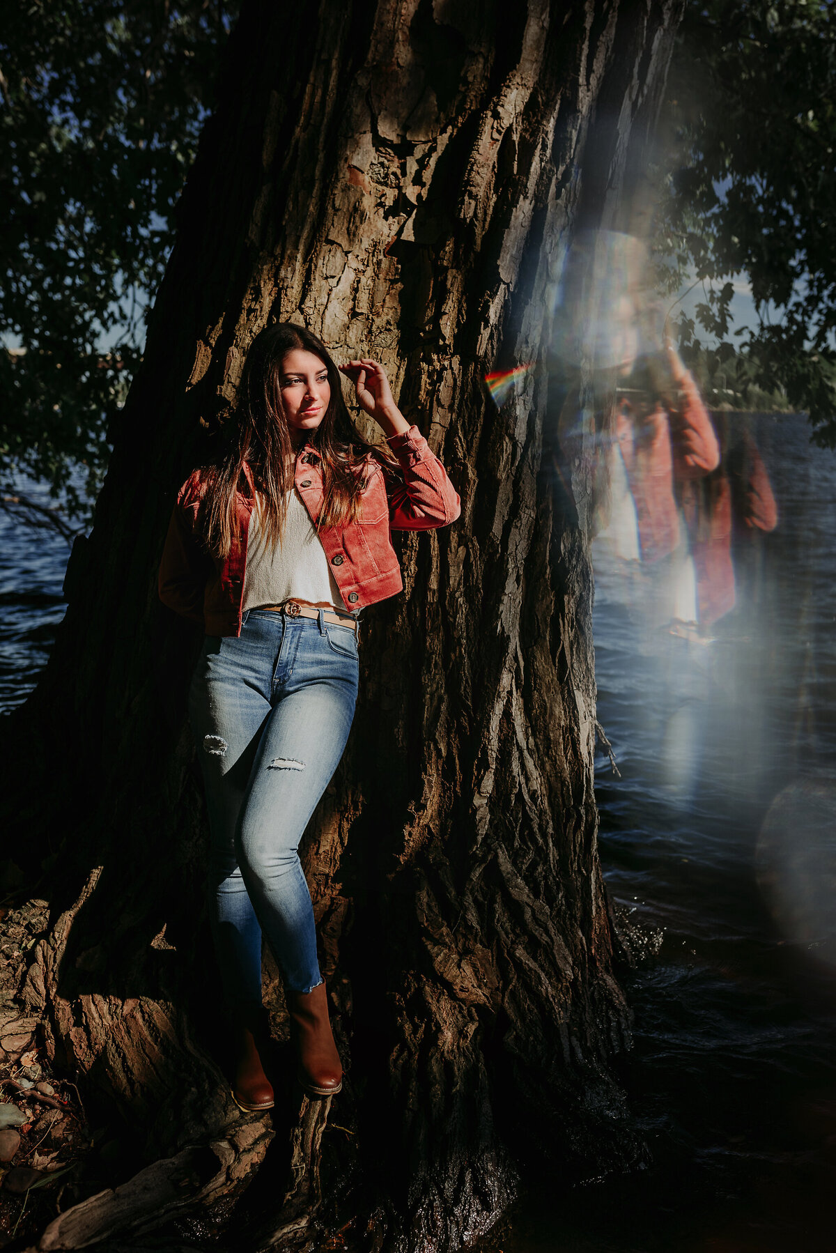 Stillwater senior standing against a tree on the St. Croix River in Stillwater, MN