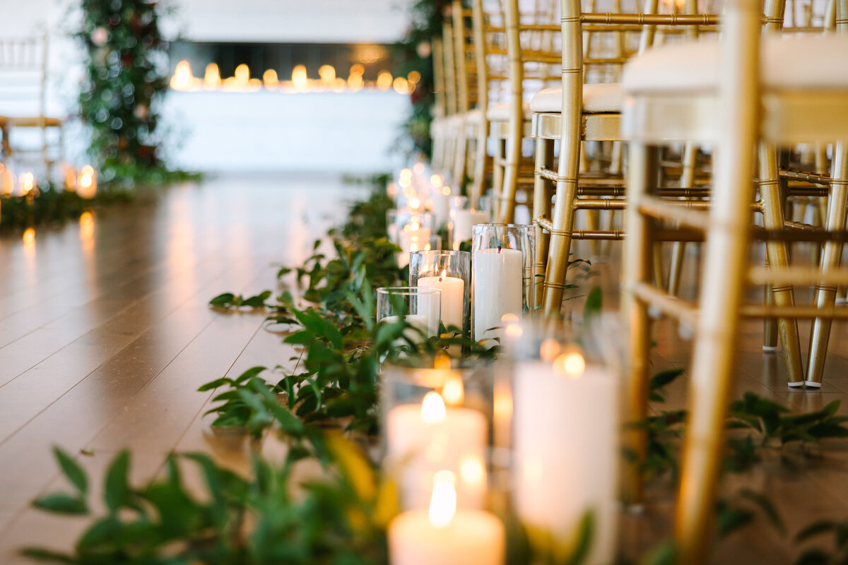 Close up of candles and greenery on the wedding aisle