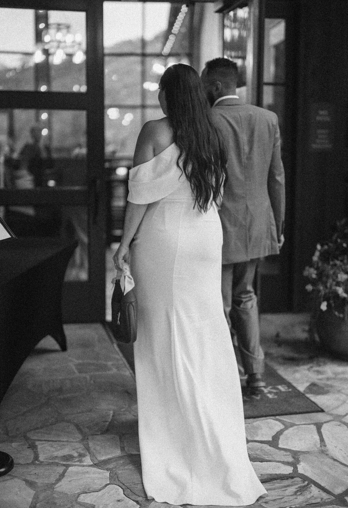 Black and white photo of a wedding guest walking into the reception venue at Castle Ladyhawke.