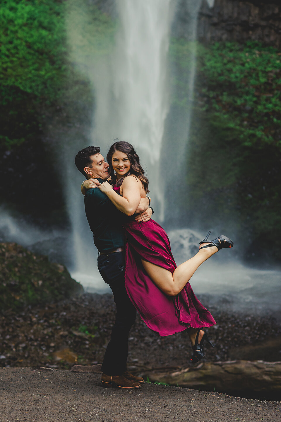engaged couple hugging at waterfall