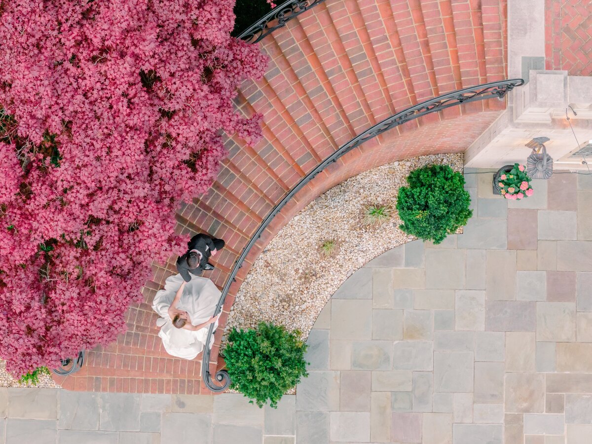 Stunning drone image of the bride and groom walking up the stairs at the estate at river run