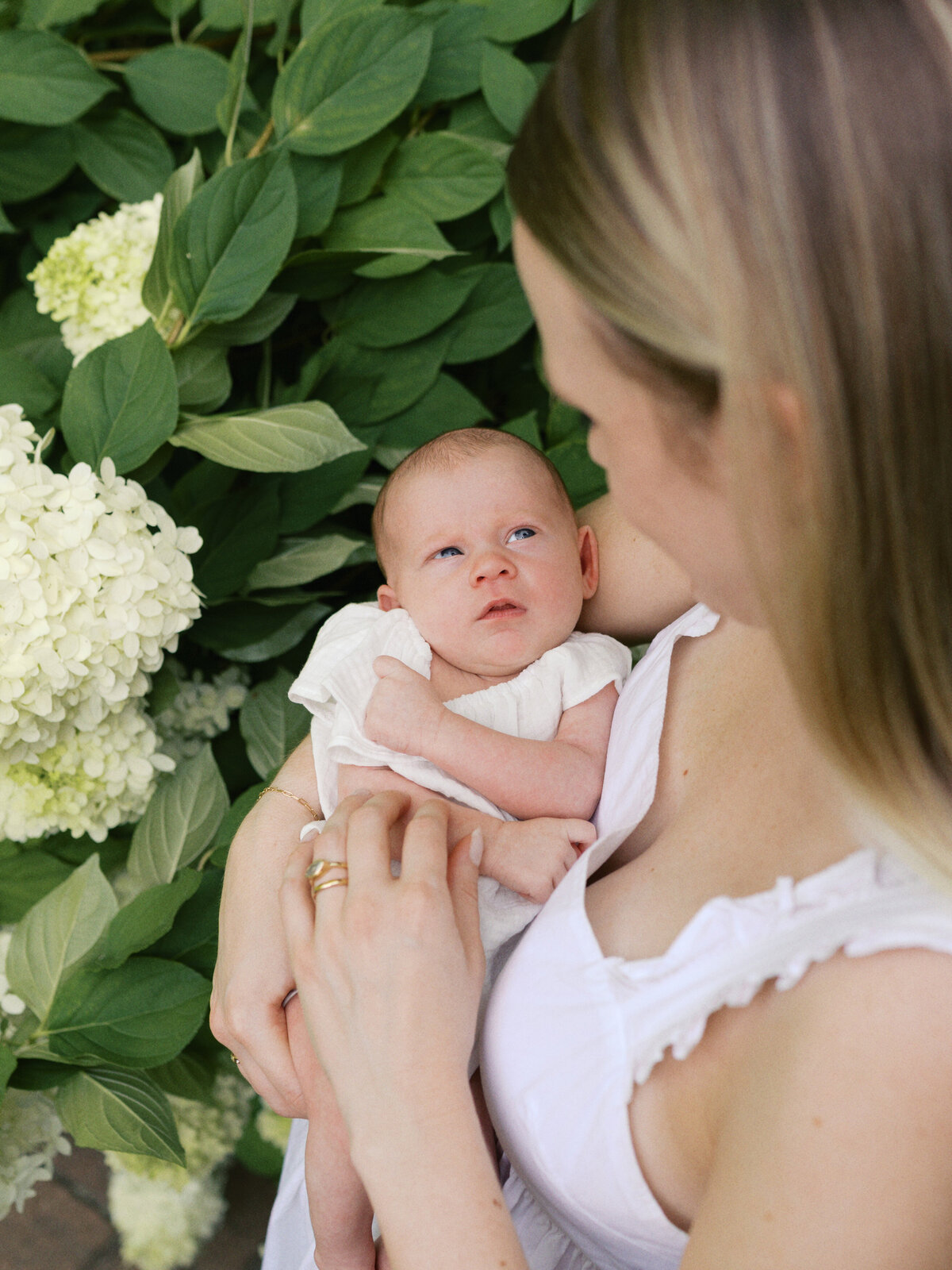 mother-holding-newborn-in-a-garden