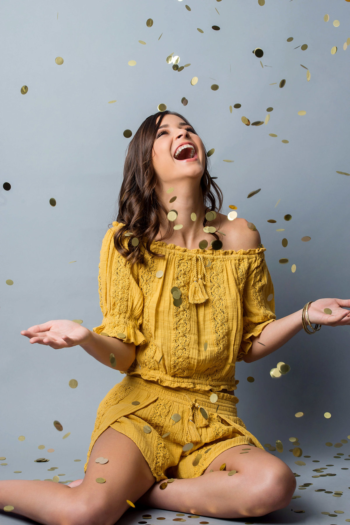 senior with confetti and yellow outfit