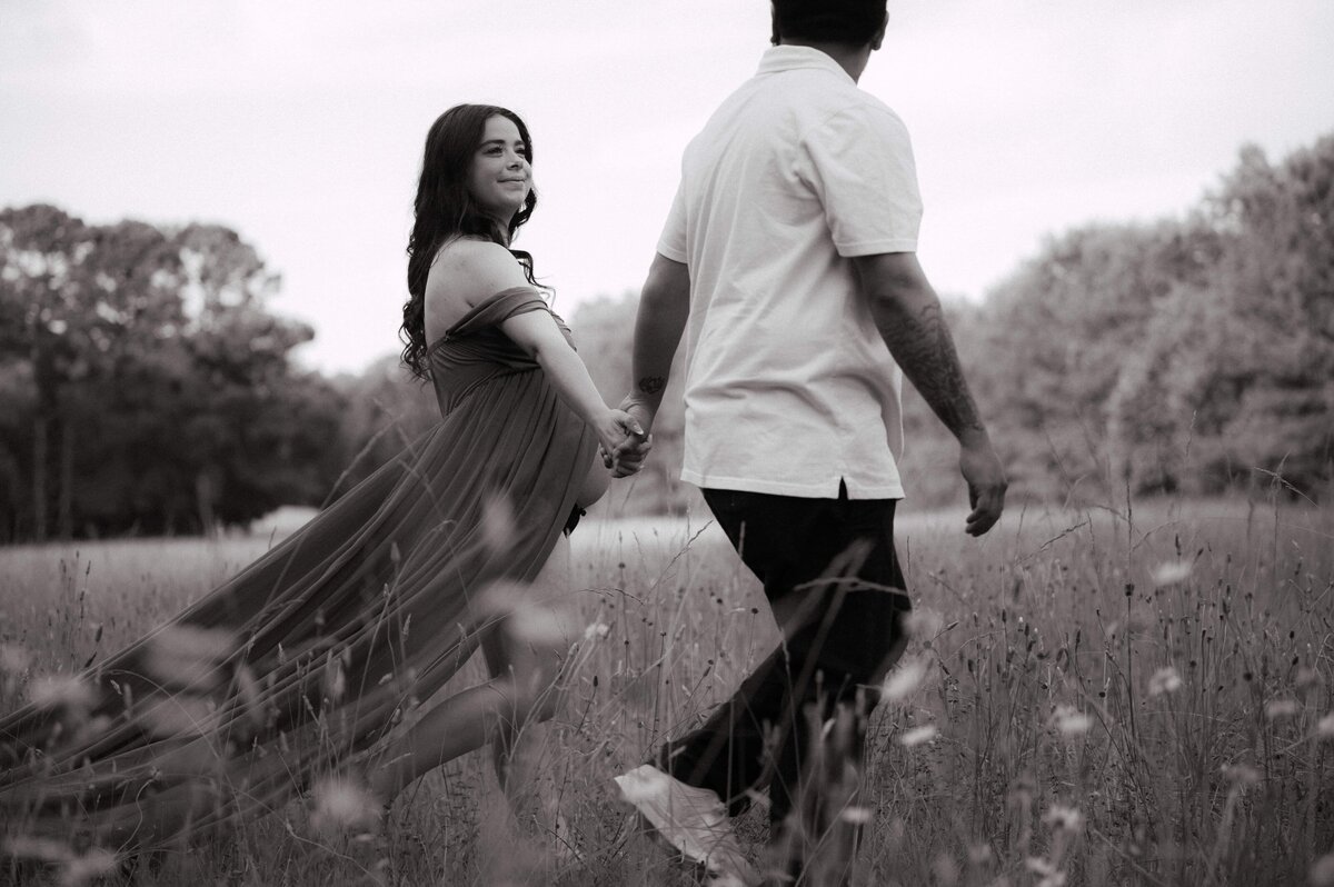 Newly wed couple stroll in a field photographed by Kristen Vann