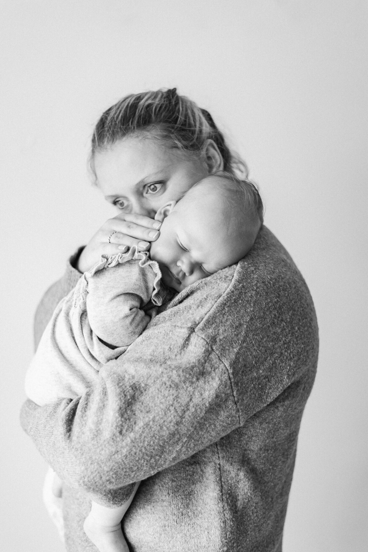 mother holder baby girl on her shoulder at milestone photoshoot in billingshurst