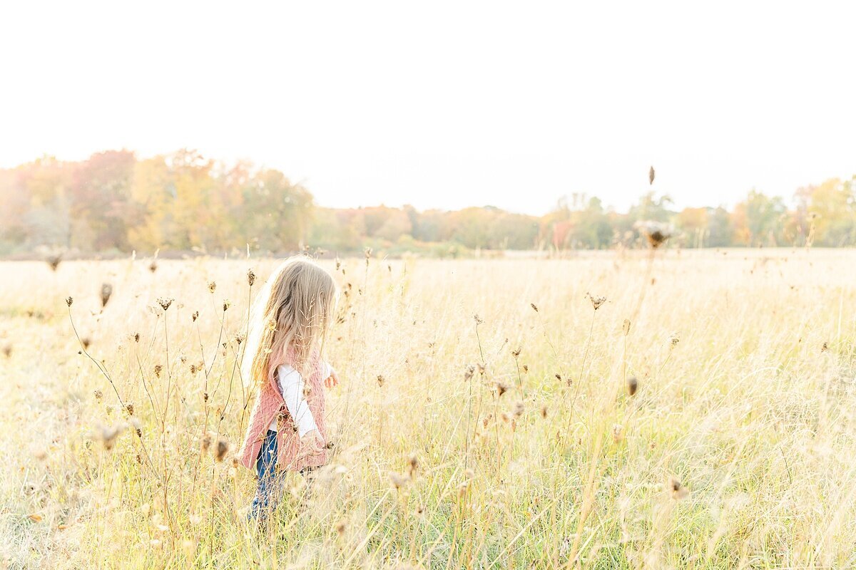 girl in field during outdoor newborn photo session with Sara Sniderman Photography