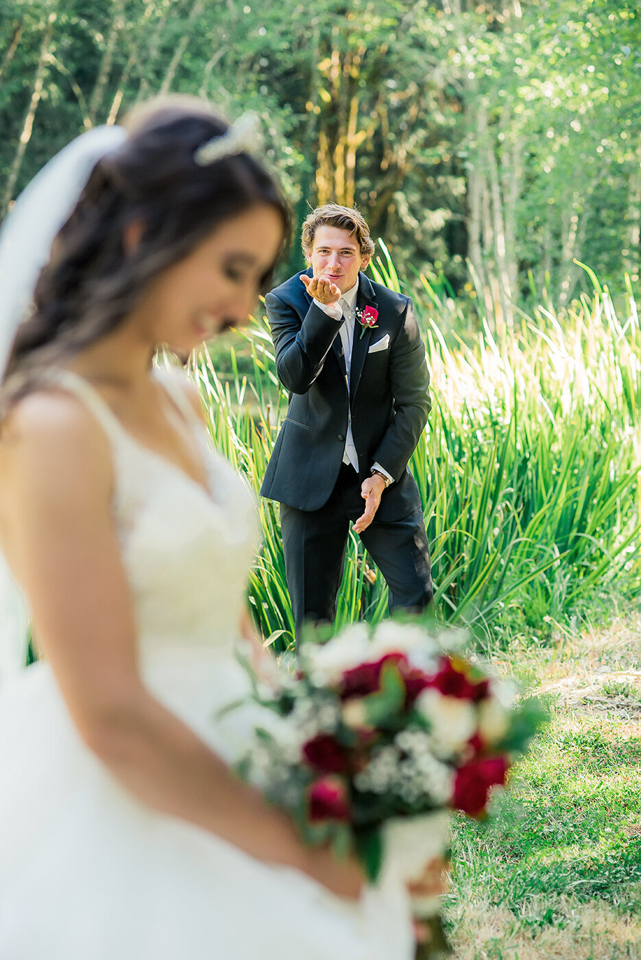 groom blowing kiss to bride