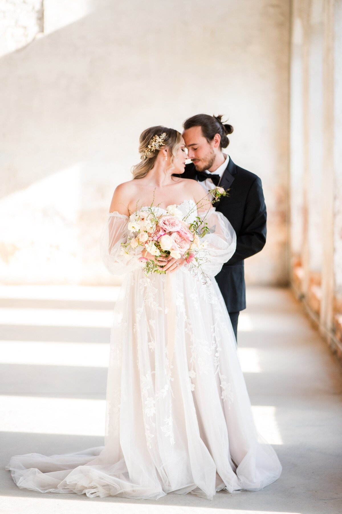A newly married couple nestles together in Providence Cotton Mill wedding venue near Charlotte, NC.