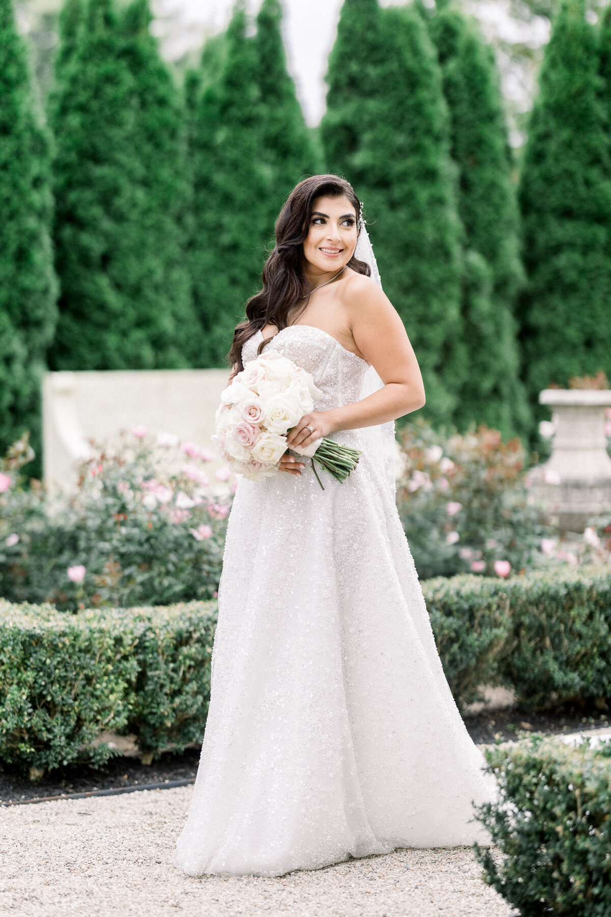 bride poses n the rose gardens of rosecliff mansion in newport rhode island