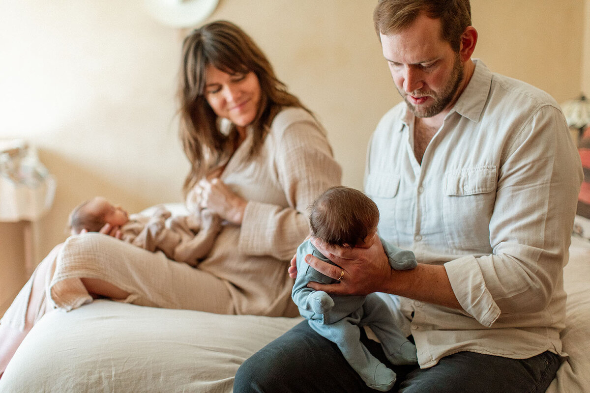 Parents holding twin babies together - Sara James documents double joy and twin parenting moments during specialized newborn photography sessions for multiple birth families in San Antonio Texas
