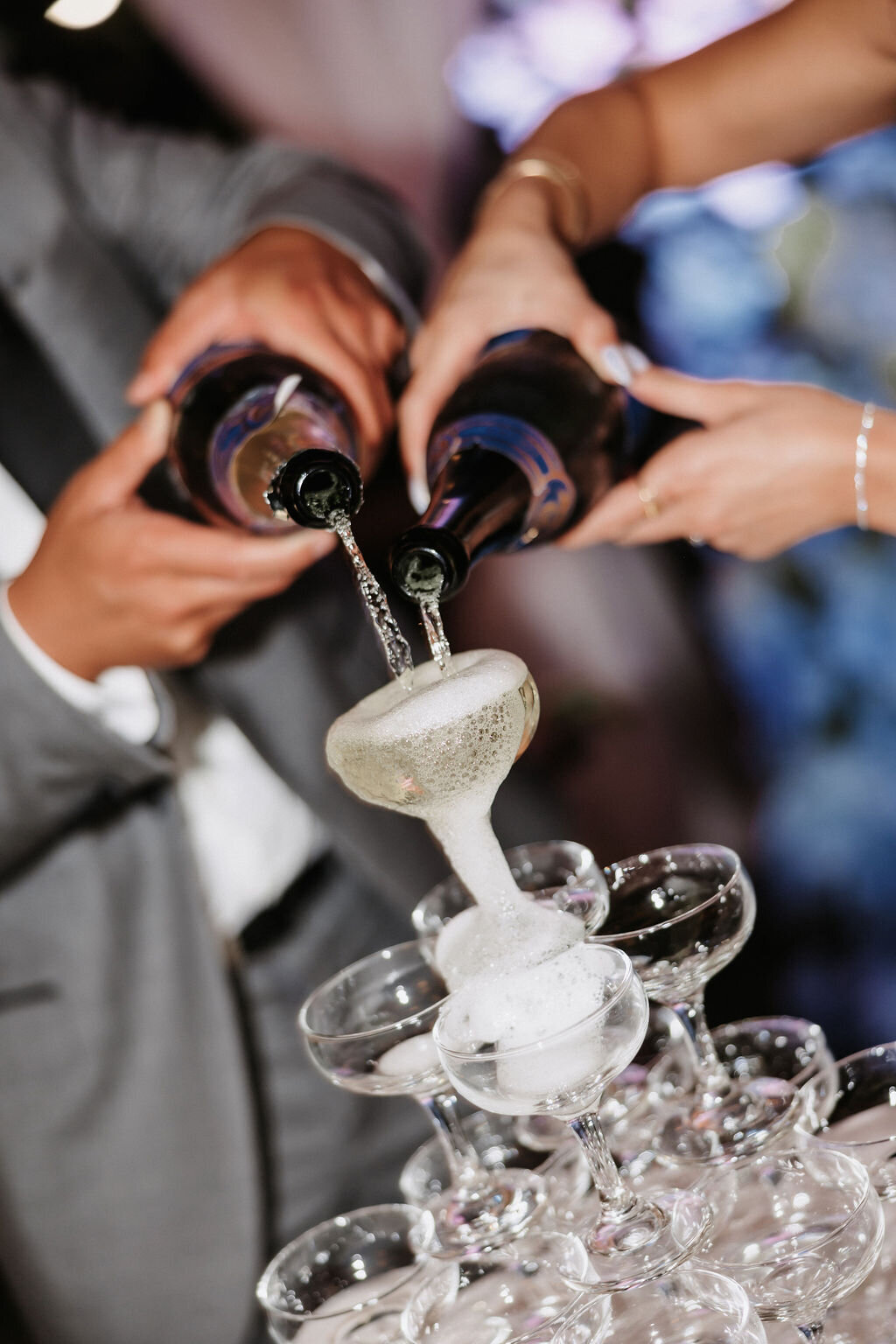 champagne tower close up of champagne being poured by bride and groom