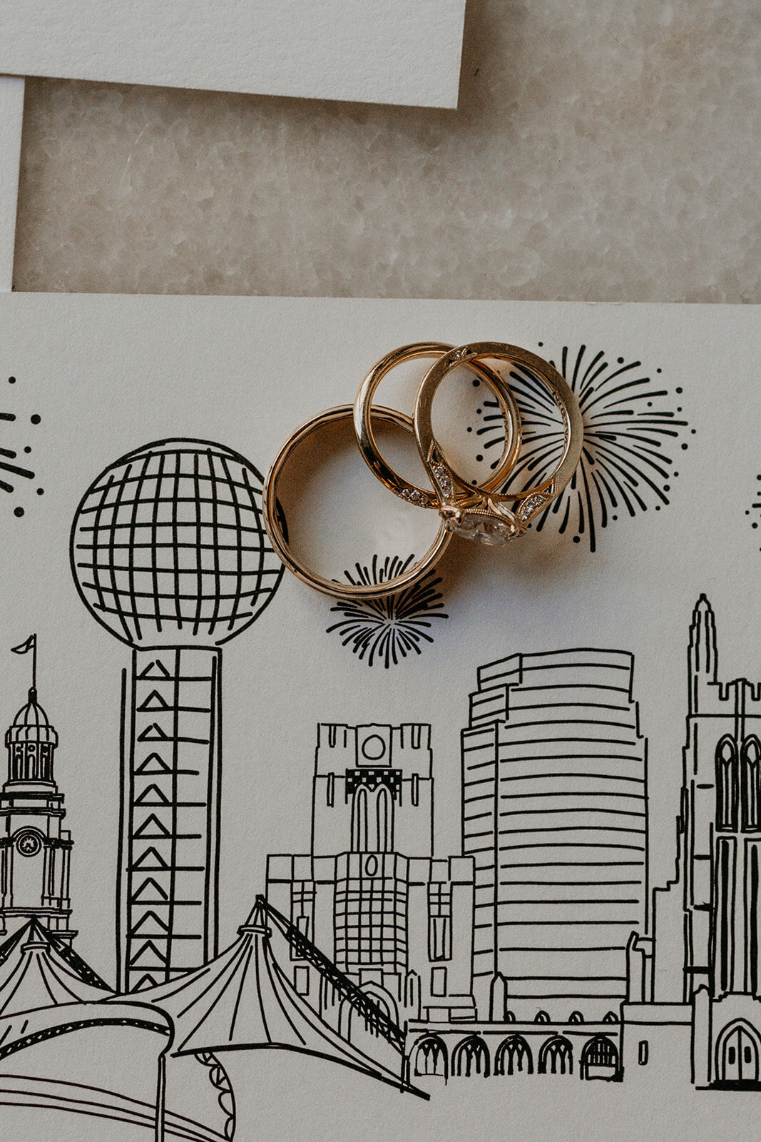 close up of a bride and grooms rings on their invitations