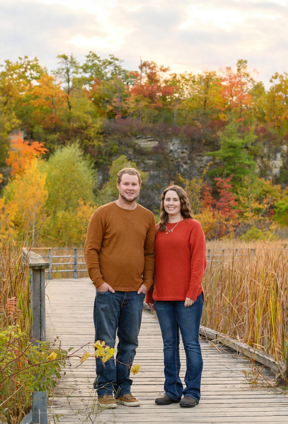 adult brother and sister standing on a bridge for their fall family photos in Burlington, ON