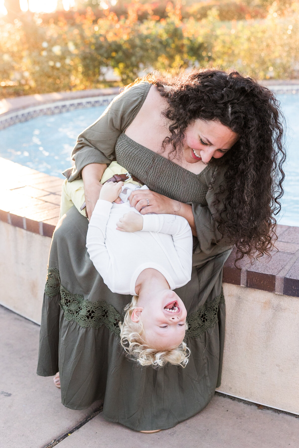 mother and son playing by fountain