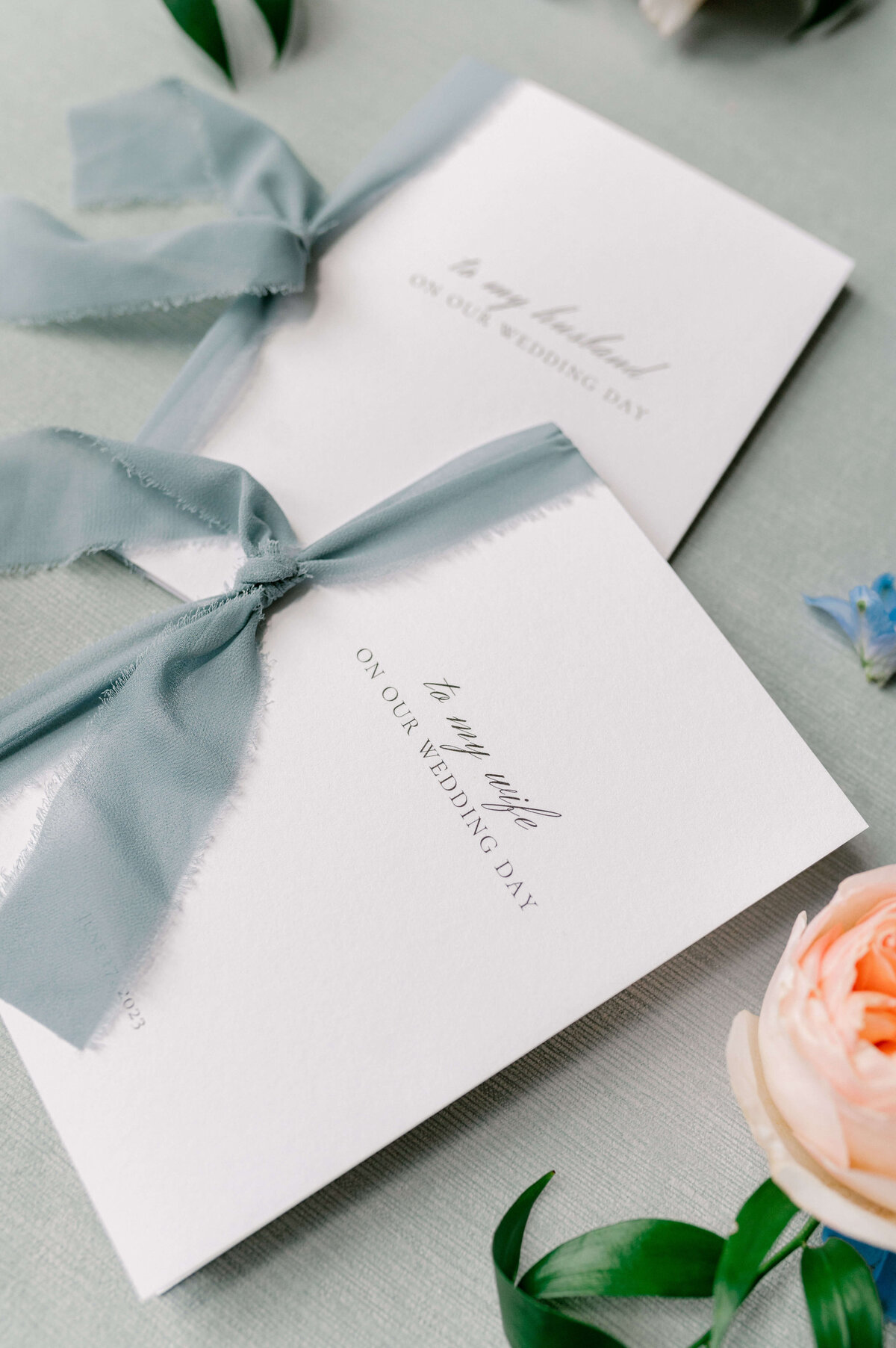 a detail photo of his and her vows tied with a blue ribbon.
