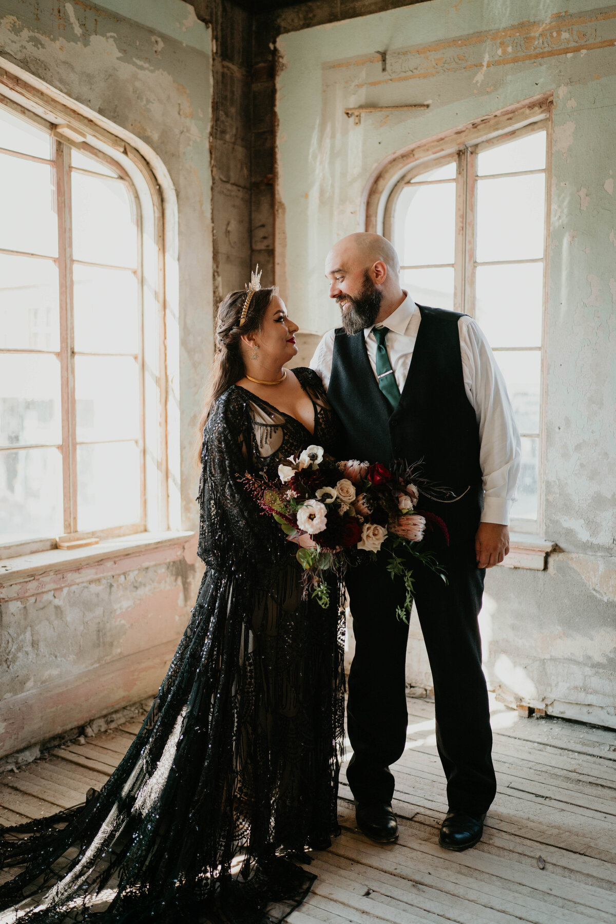 Bride in black dress and groom smiling at each other in The Ruins at the Astor