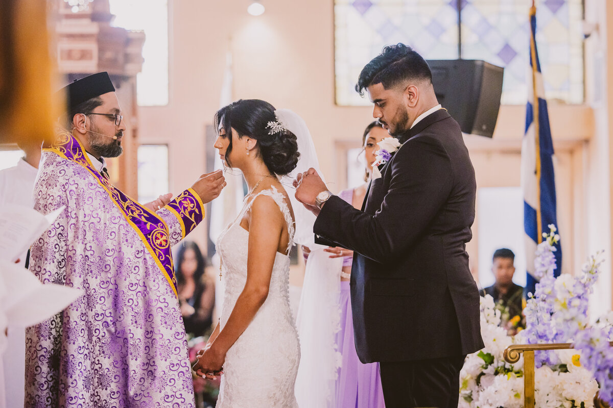 Indian malayali christian groom tying the minnu string around the bride's neck during the wedding ceremony