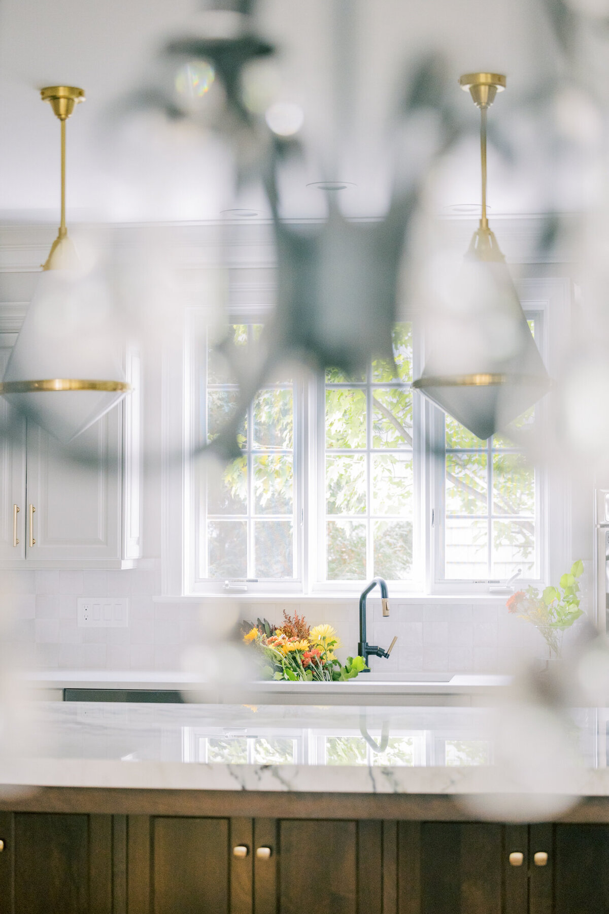 A creative interior design photograph of a kitchen shot through a chandelier
