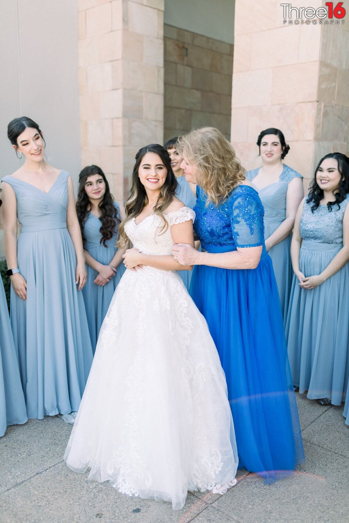 Mother of the Bride poses with her daughter as the Bridesmaids surround them