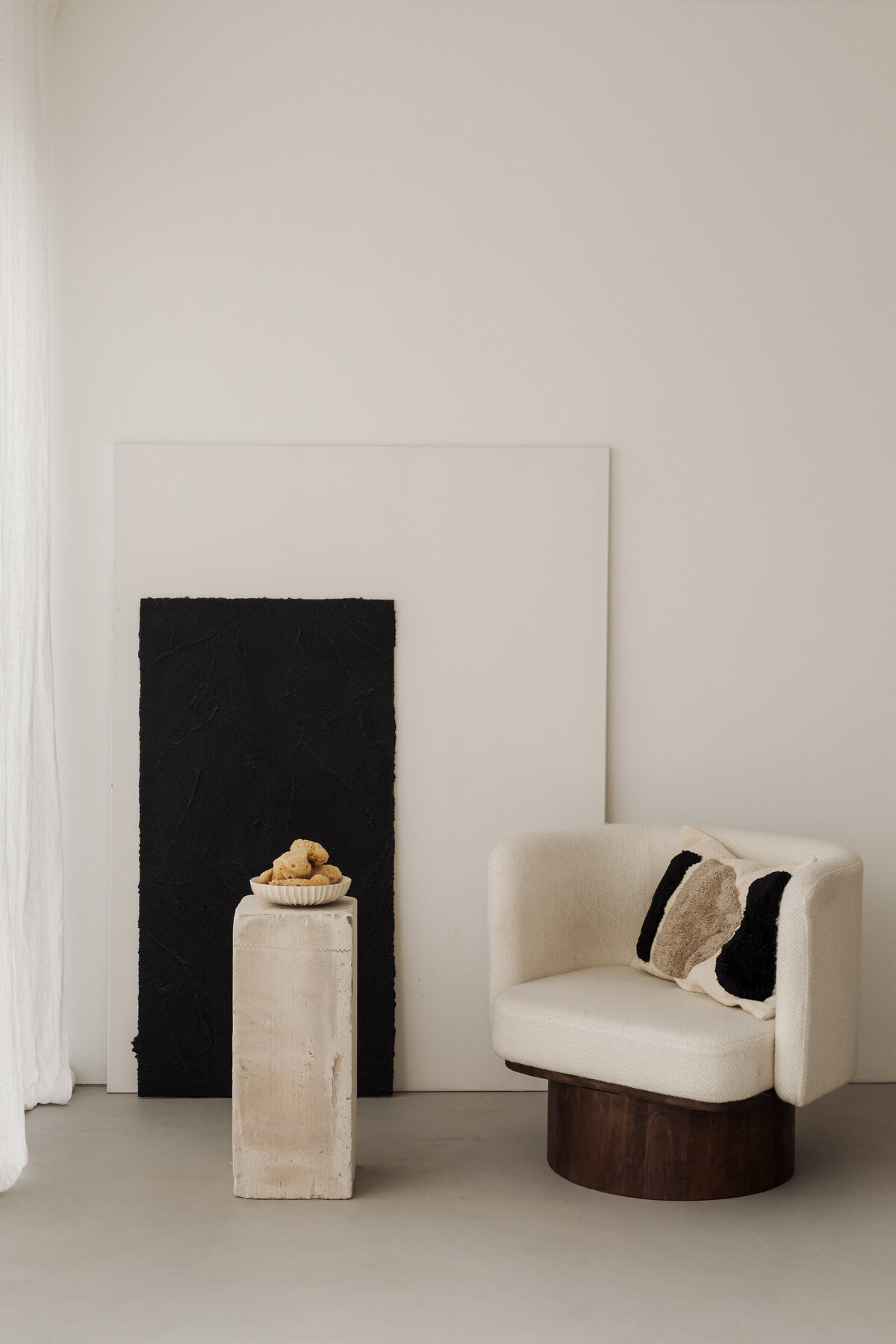 kaboompics_a-cozy-cream-colored-armchair-placed-next-to-minimalist-black-and-white-artwork-with-a-small-side-table-adorned-with-natural-objects-36989