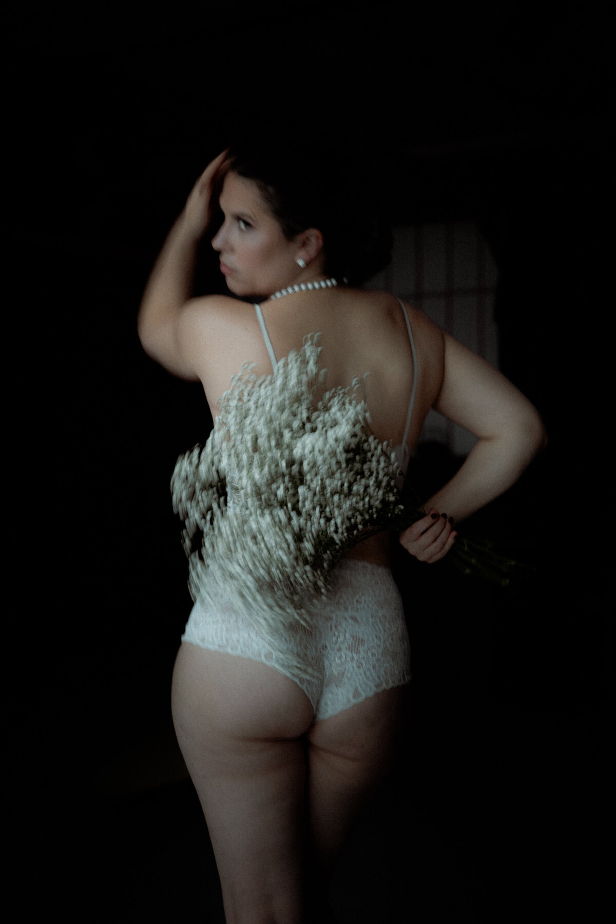 Profil de femme en sous-vêtements avec flou de mouvement sur les fleurs boudoir