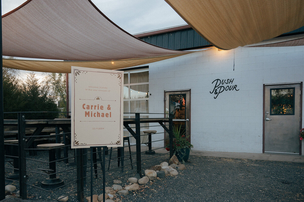 A building with the words push and pour written on the side and a welcome sign that says Carrie and Michael.