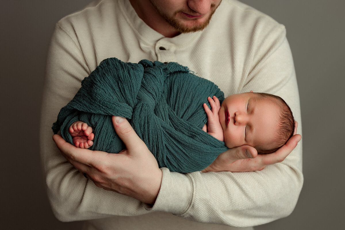 dad holding newborn baby in kalispell photographer studio