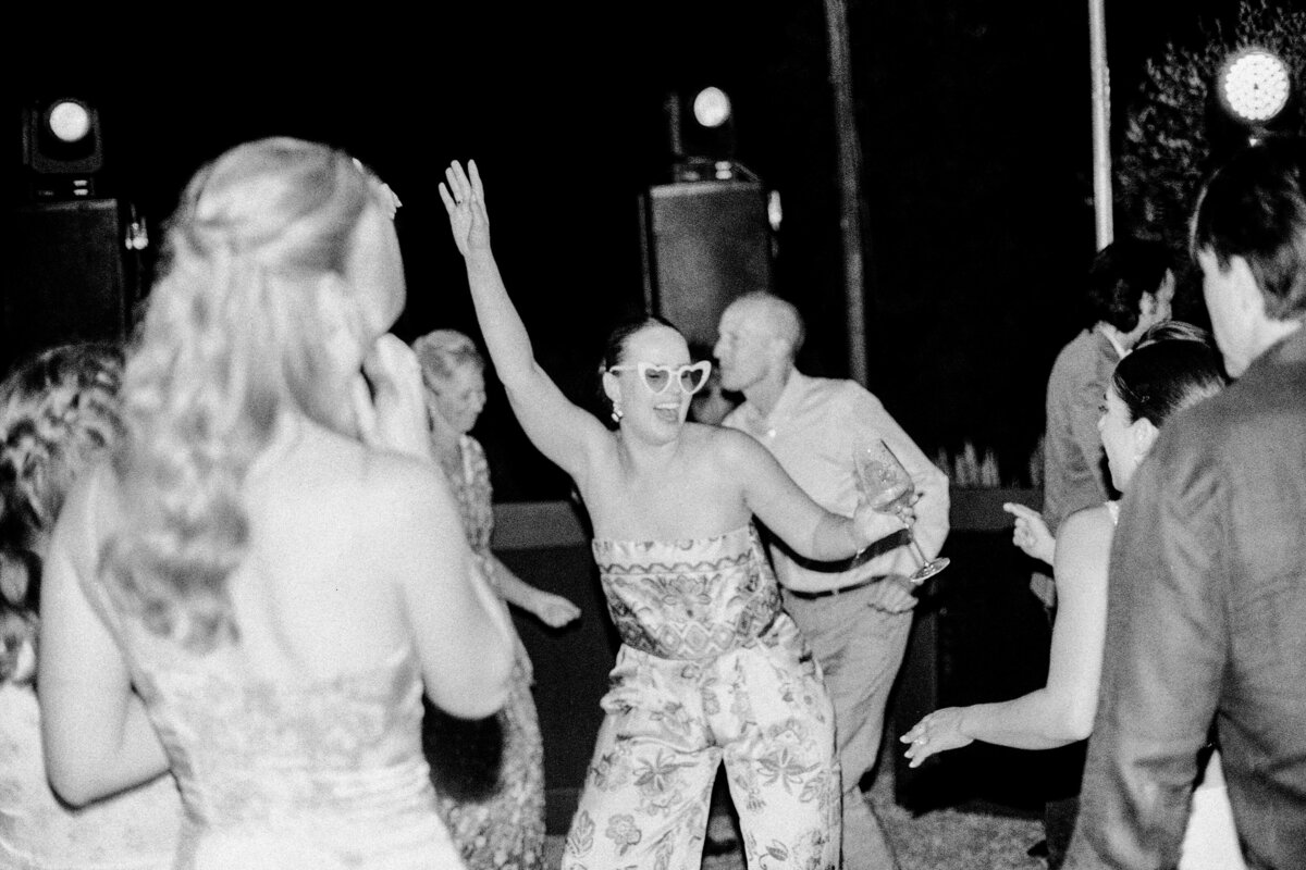 Black and white film photograph of guest dancing at wedding reception photographed by Italy wedding photographer at Villa Montanare Tuscany wedding