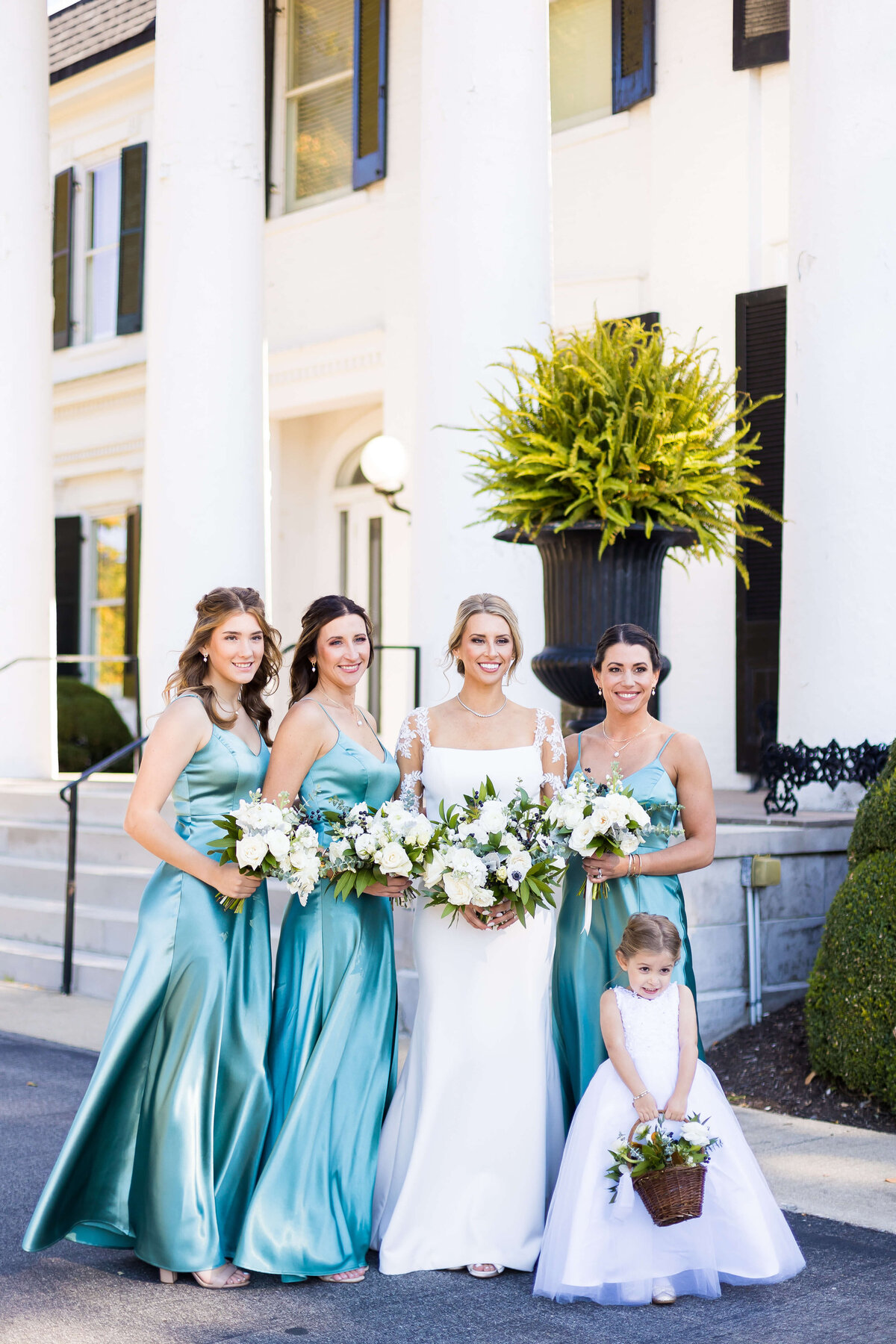 Bride with bridesmaids in blue dresses at The Carrick House Wedding venue in Lexington, KY
