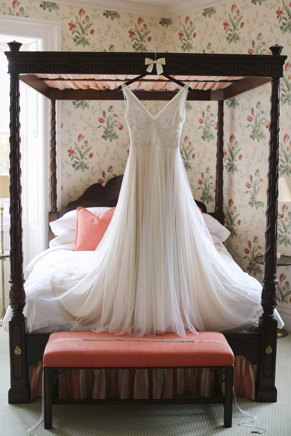 Wedding dress hanging from poster bed