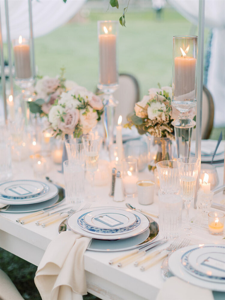 Custom table settings with candles at an outdoor wedding venue
