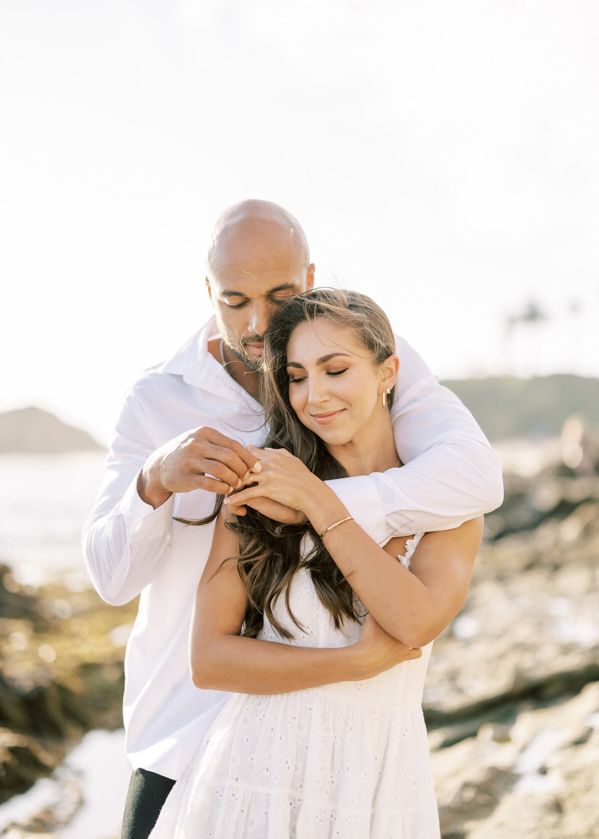 engaged couple embracing at the beach