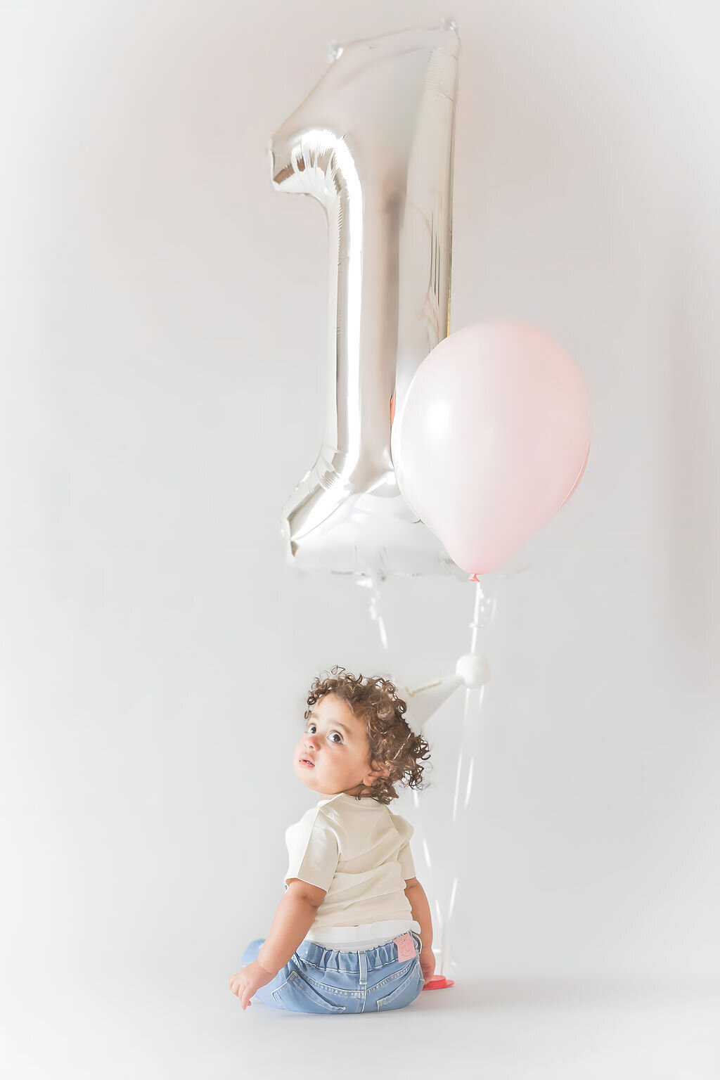 Baby girl with cake during first birthday session in Mooresville NC