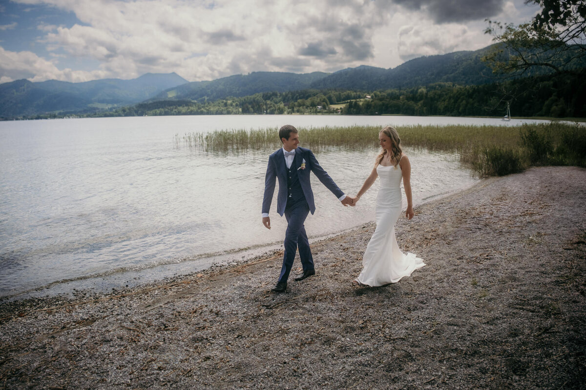 The wedding couple walks into their future by a lake - outside couple session.