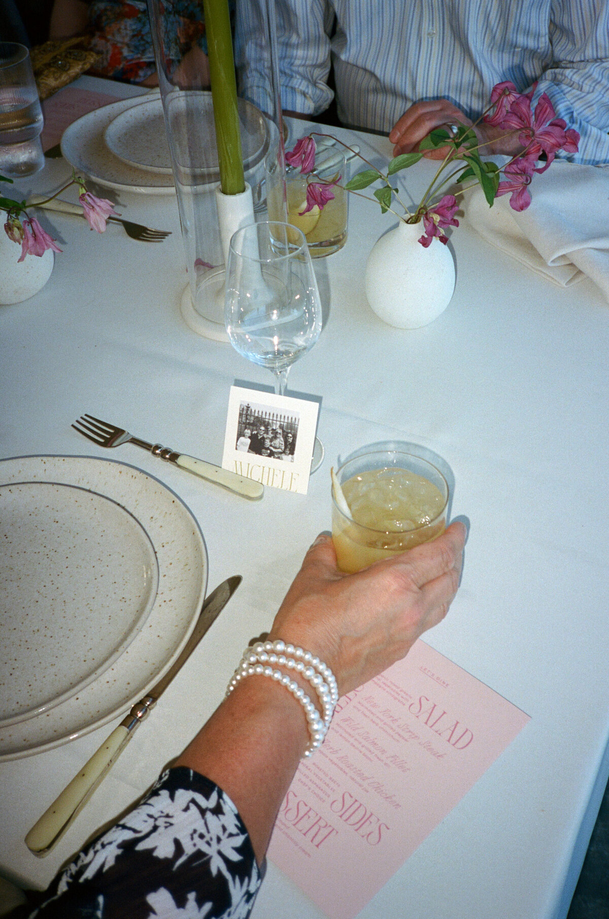 Guest holding cocktail while seated at The Orchard venue.