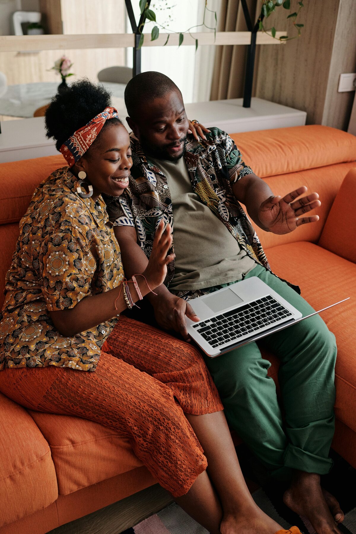 Man and woman on couch with computer booking an appointment